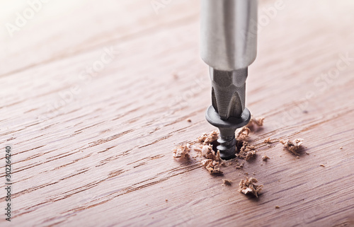 screwdriver screw in a wood oaks plank photo