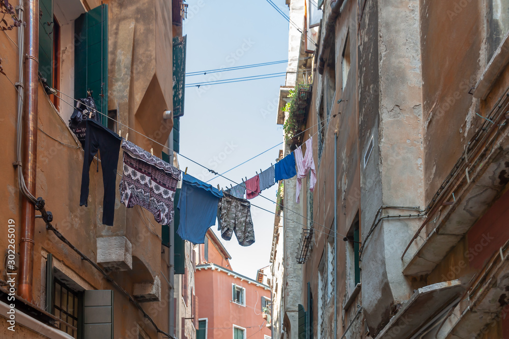 Lines of colorful clothes hanging rope between adobe facade buildings