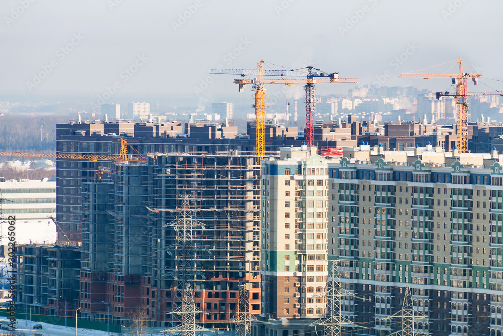 Winter construction work site high-rise appartment buildins with many cranes