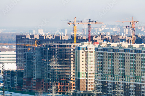 Winter construction work site high-rise appartment buildins with many cranes