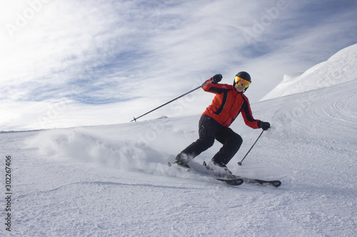 Male skier on slope in mountains sunny weather