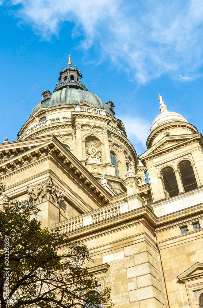 Exterior facade of St. Stephen's Basilica in Budapest, Hungary on vertical photo with blue sky above. Roman Catholic basilica built in neoclassical style. Historical architecture in Hungarian capital