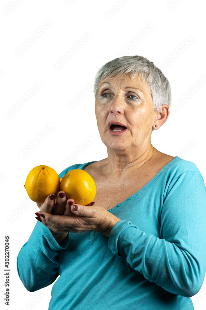 older woman with gray and White hair with open mounth and oranges in hands in isolated White background older woman with gray and White hair with open mounth and oranges in hands in isolated White background