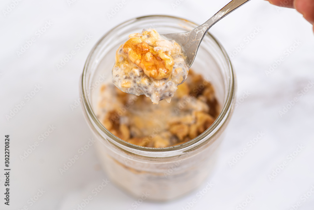 Overnight oats with chia seeds, walnuts and yogurt, on a white marble background. Overnight oats with chia seeds, walnuts and yogurt, on a white marble background.