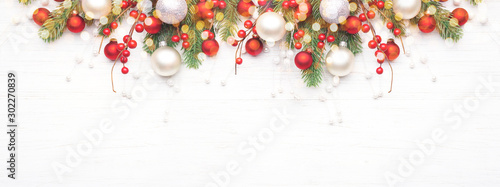 Classic Christmas composition with fir branches and white and red baubles on white wooden background. Noel banner for website.