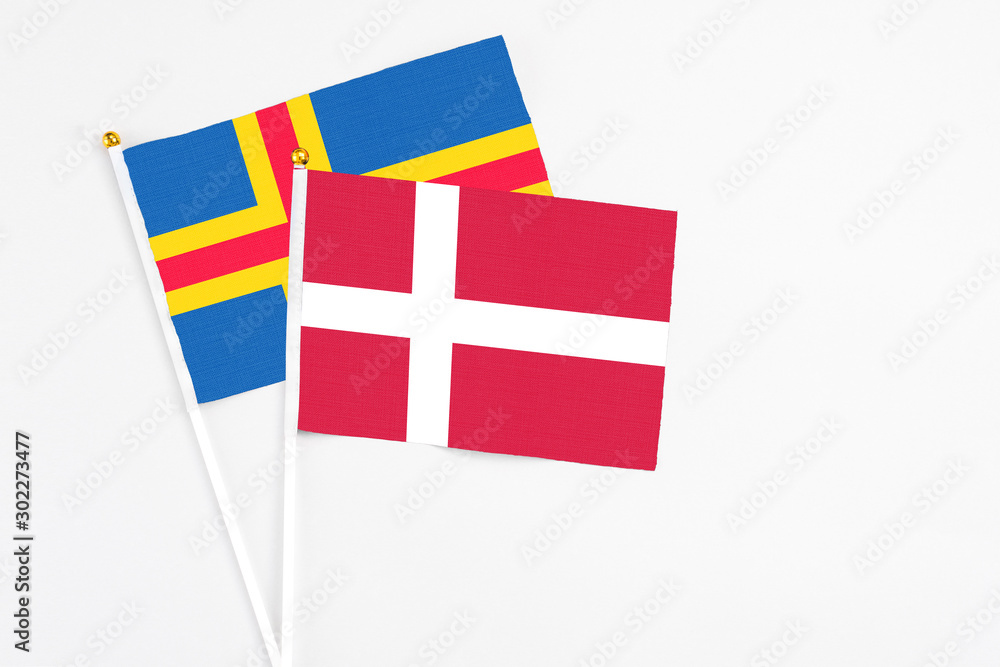 Denmark and Aland Islands stick flags on white background. High quality fabric, miniature national flag. Peaceful global concept.White floor for copy space.