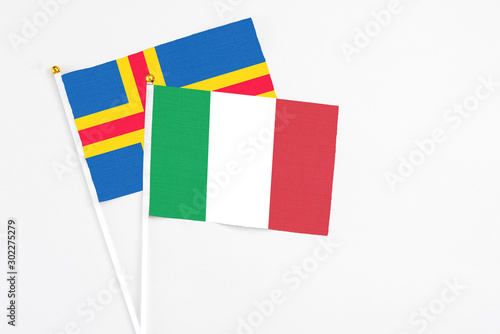 Italy and Aland Islands stick flags on white background. High quality fabric, miniature national flag. Peaceful global concept.White floor for copy space.