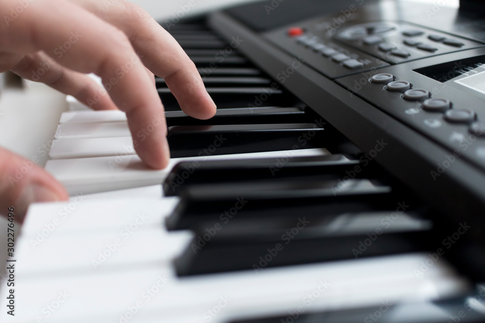 Obraz premium Close-up photo of pianist, hands on musical modern electronic synthesizer and keys. Music modern instrument concept. Man, person is playing the digital piano. Fingers on the keys.