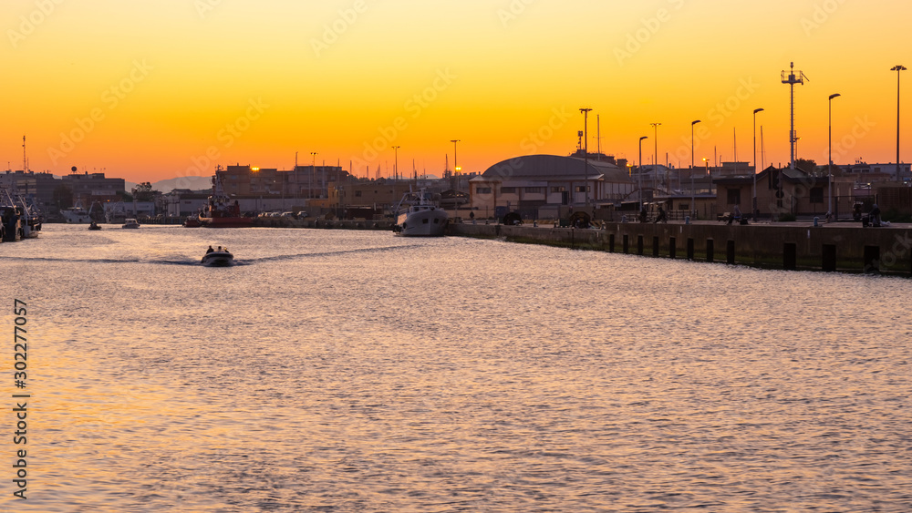 Little boat for fishing in Fiumicino port at sunrise.