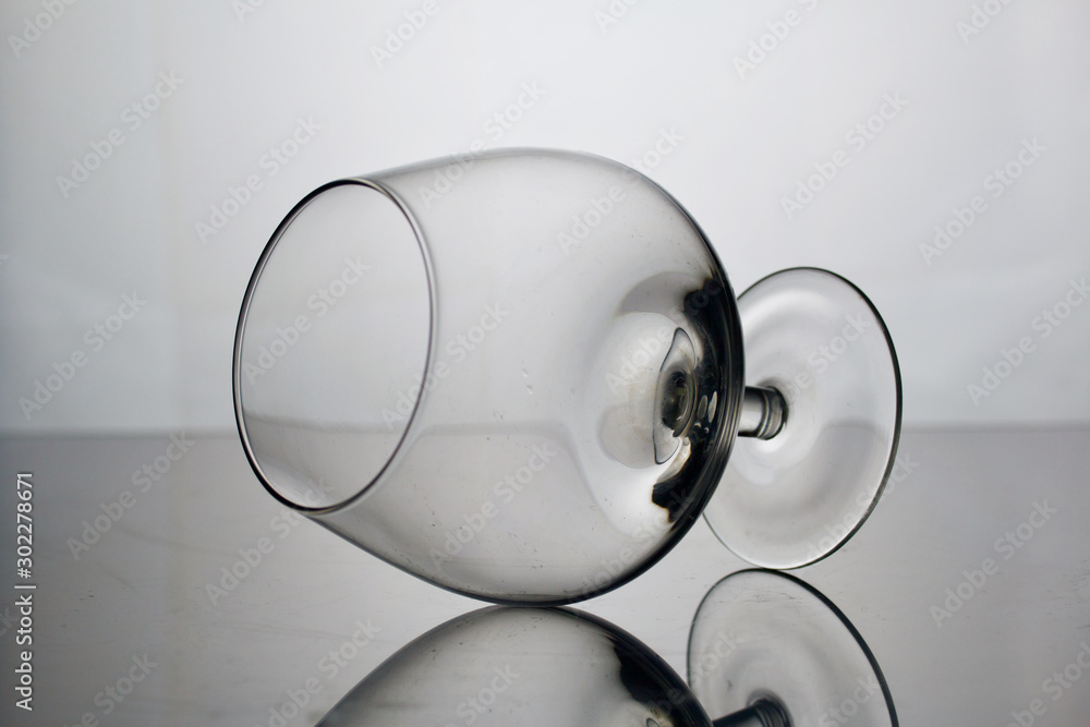 Short-stemmed wine glass. Lies on its side, photographed in the light.