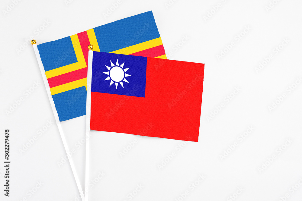 Taiwan and Aland Islands stick flags on white background. High quality fabric, miniature national flag. Peaceful global concept.White floor for copy space. Taiwan and Aland Islands stick flags on white background. High quality fabric, miniature national flag. Peaceful global concept.White floor for copy space.