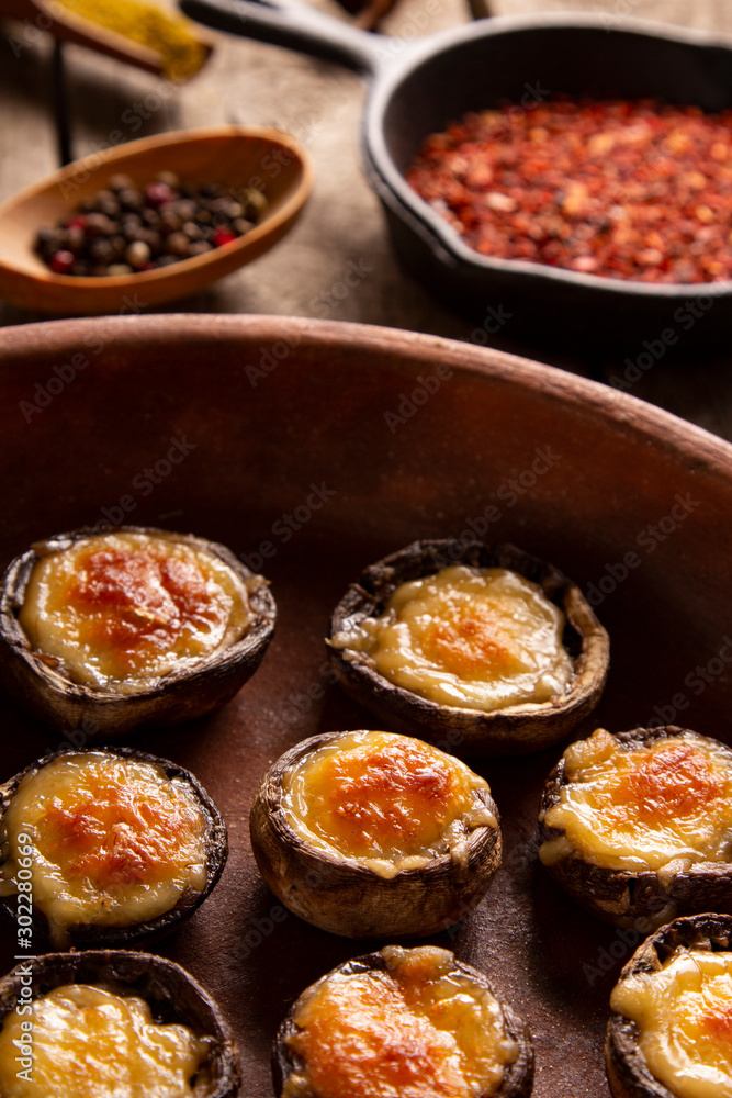 Roasted mushrooms with vegetables and parsley under melting cheese Roasted mushrooms with vegetables and parsley under melting cheese