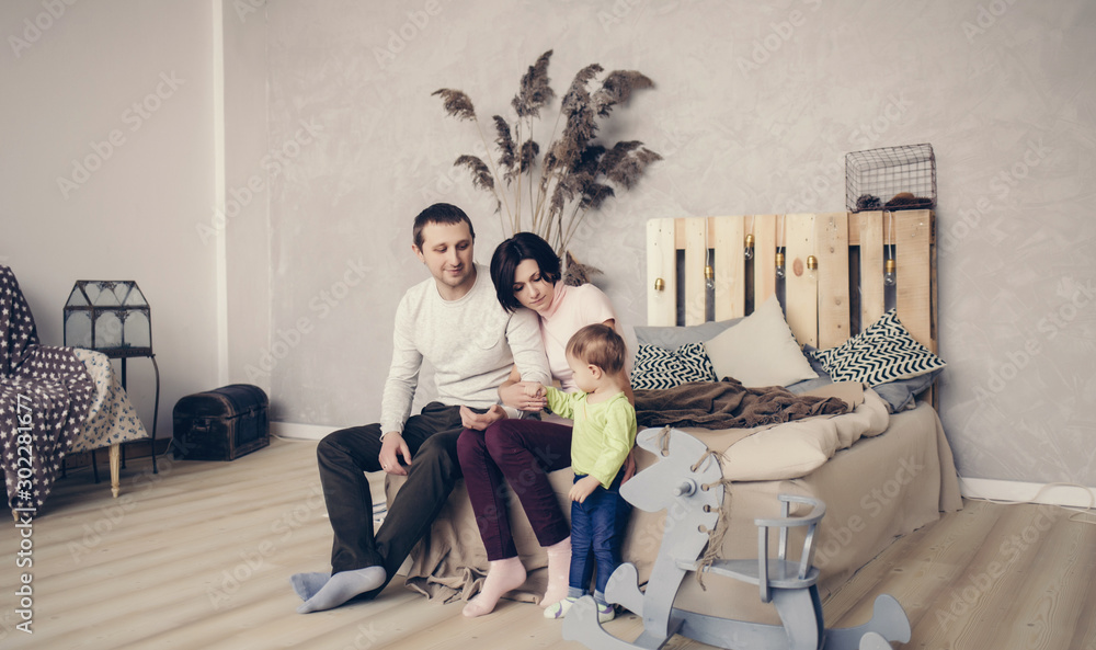 Happy family sitting on bed together. Happy family sitting on bed together.