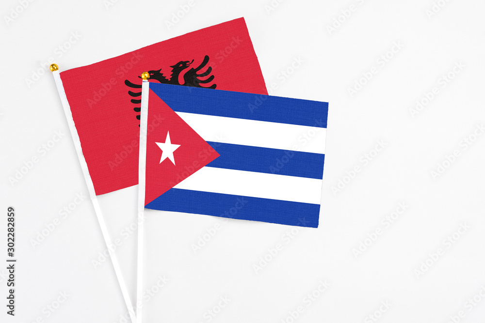 Cuba and Albania stick flags on white background. High quality fabric, miniature national flag. Peaceful global concept.White floor for copy space.