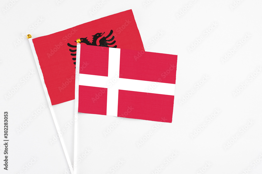 Denmark and Albania stick flags on white background. High quality fabric, miniature national flag. Peaceful global concept.White floor for copy space.
