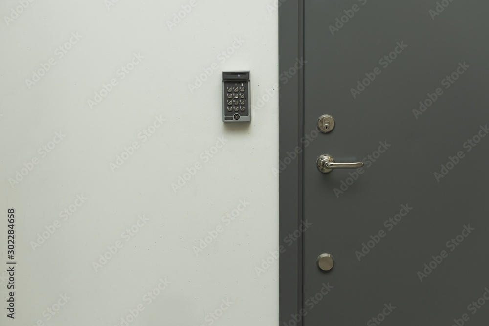 Close up view of grey metal door with digital code lock to the left. Security concept, Close up view of grey metal door with digital code lock to the left. Security concept,