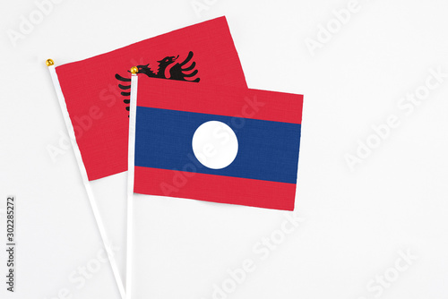 Free Download Laos and Albania stick flags on white background. High quality fabric, miniature national flag. Peaceful global concept.White floor for copy space. - GFXLoad