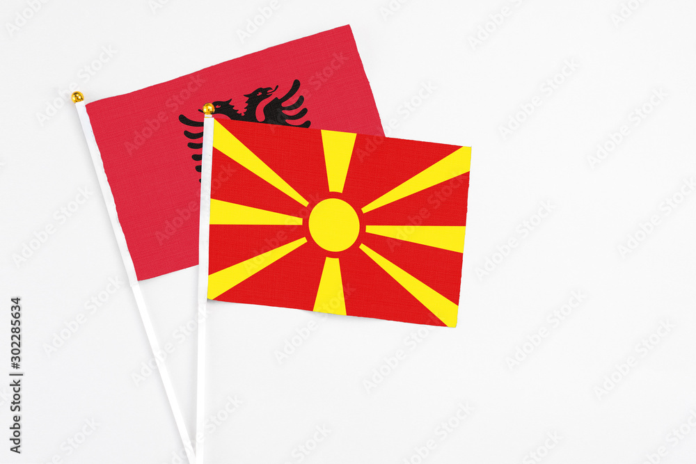 Macedonia and Albania stick flags on white background. High quality fabric, miniature national flag. Peaceful global concept.White floor for copy space.