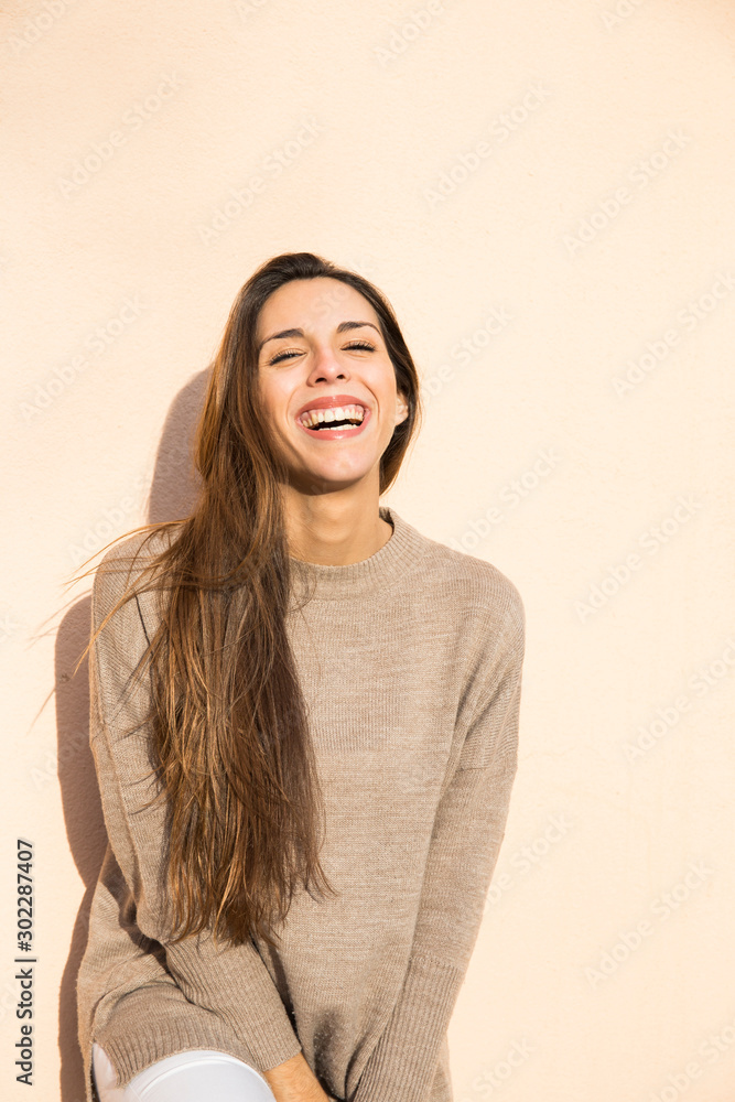 Laughing woman leaning against a wall in Boadilla del Monte Laughing woman leaning against a wall in Boadilla del Monte