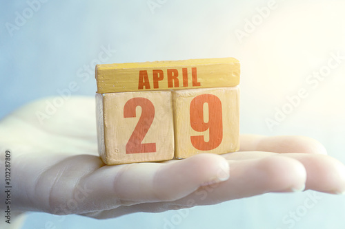 april 29th. Day 29 of month,Handmade wood cube with date month and day on female palm spring month, day of the year concept