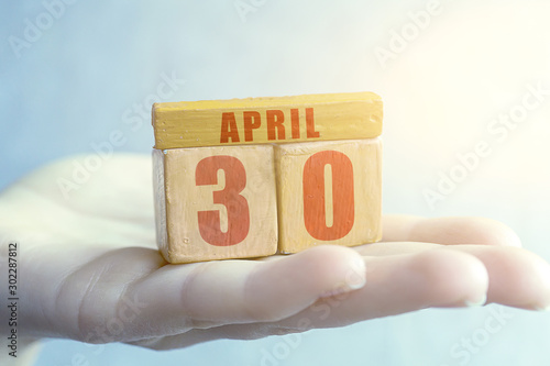 april 30th. Day 30 of month,Handmade wood cube with date month and day on female palm spring month, day of the year concept