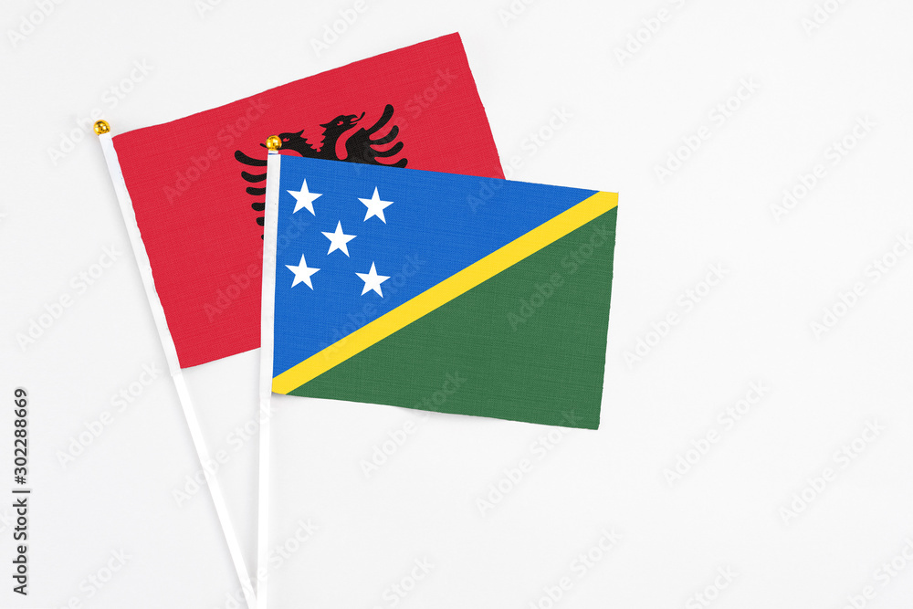 Solomon Islands and Albania stick flags on white background. High quality fabric, miniature national flag. Peaceful global concept.White floor for copy space. Solomon Islands and Albania stick flags on white background. High quality fabric, miniature national flag. Peaceful global concept.White floor for copy space.