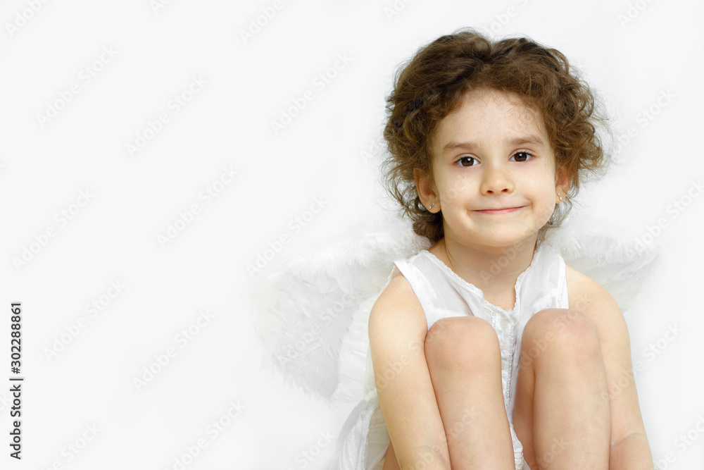 Portrait of adorable little girl with angelic face and smile in white dress and wings, isolated on white background. Portrait of adorable little girl with angelic face and smile in white dress and wings, isolated on white background.