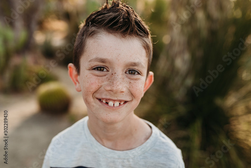 Close up portrait of cute young boy with freckles smiling photo