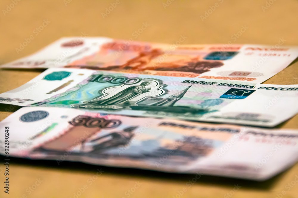 Banknotes of the Russian currency of different denominations scattered on the table - a sign of wealth and prosperity. Banknotes of the Russian currency of different denominations scattered on the table - a sign of wealth and prosperity.