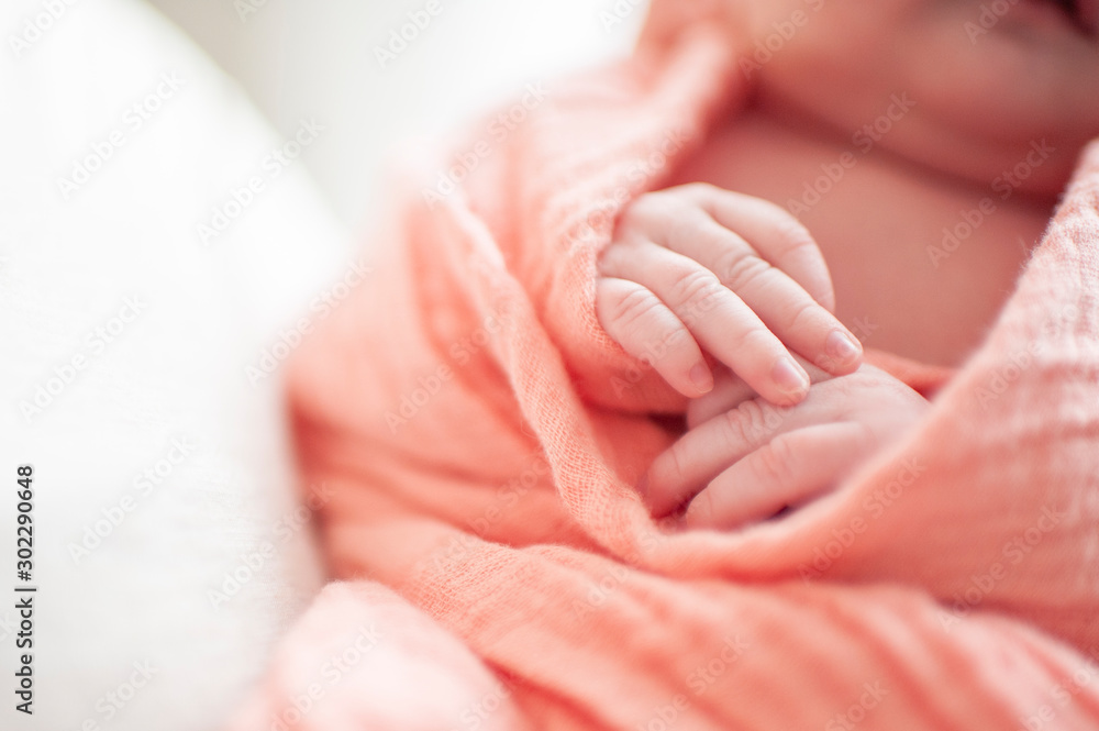 Close up of newborn baby girls hands wrapped in pink blanket Close up of newborn baby girls hands wrapped in pink blanket