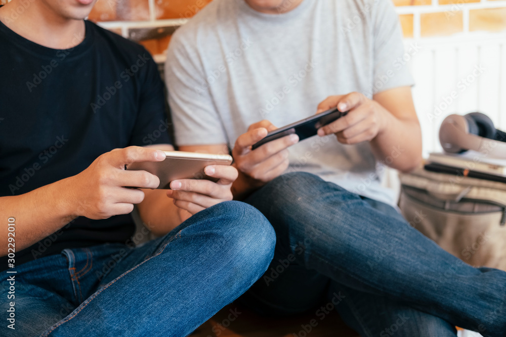 Young teenage men playing mobile game together. Young teenage men playing mobile game together.