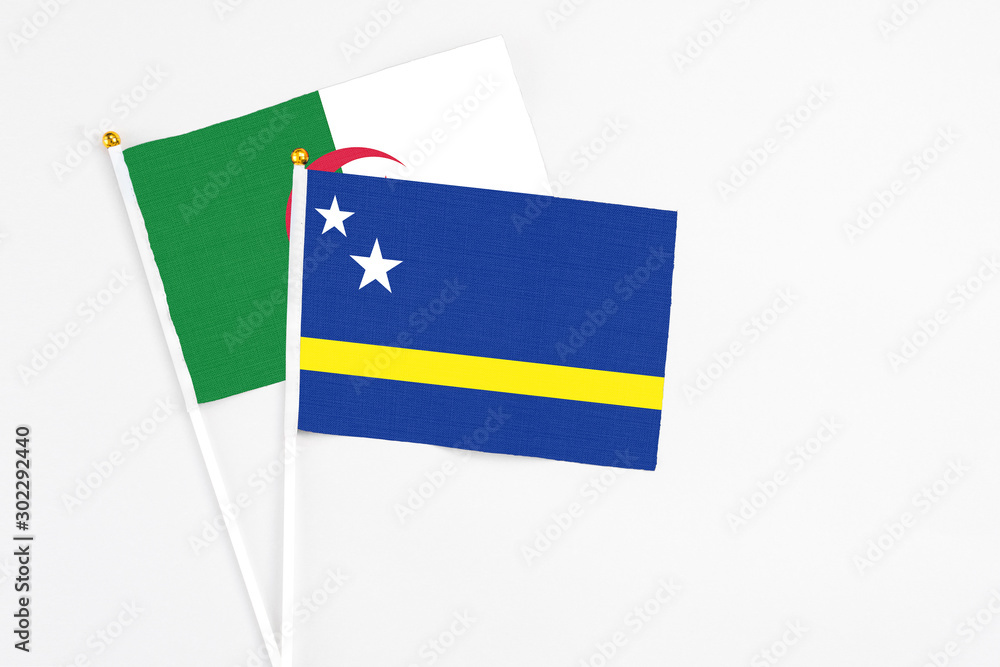 Curacao and Algeria stick flags on white background. High quality fabric, miniature national flag. Peaceful global concept.White floor for copy space. Curacao and Algeria stick flags on white background. High quality fabric, miniature national flag. Peaceful global concept.White floor for copy space.