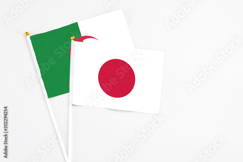 Free Download Japan and Algeria stick flags on white background. High quality fabric, miniature national flag. Peaceful global concept.White floor for copy space. - GFXLoad