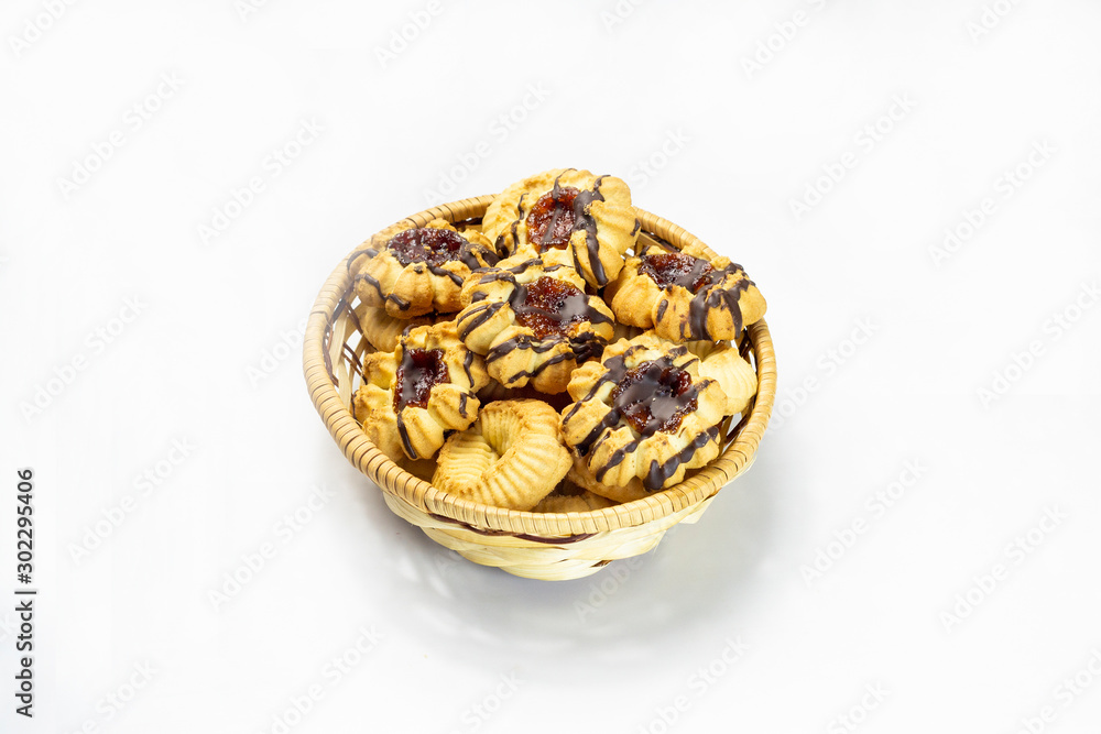 fresh cookies in a straw basket on a white background