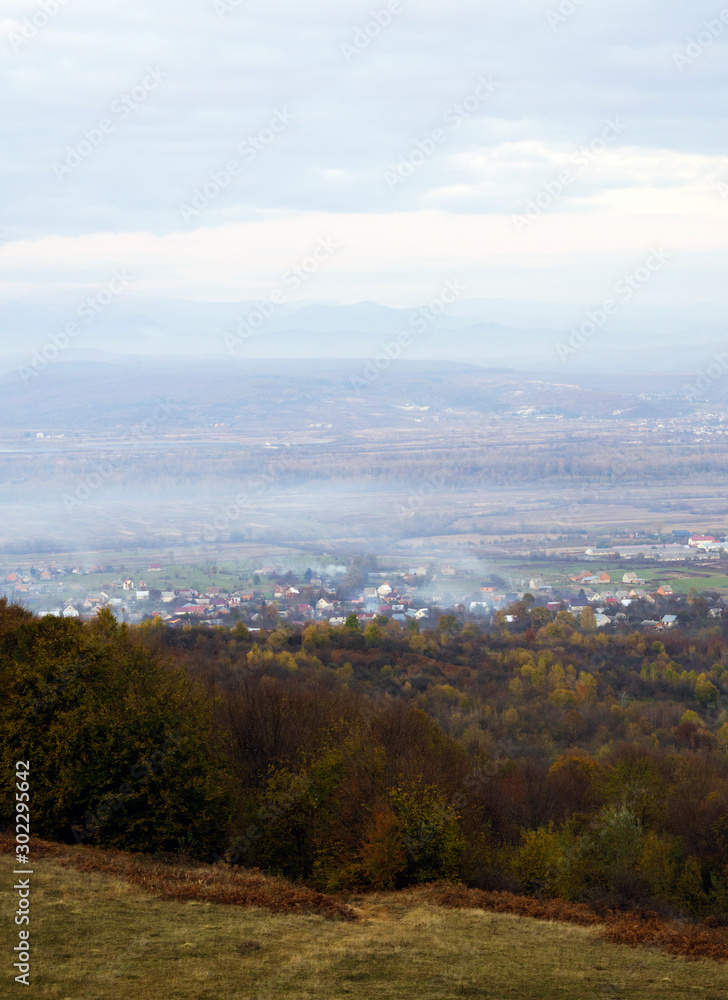 Panoramic view on fog village, Carpathian mountains, Ukraine. Vertical outdoors shot