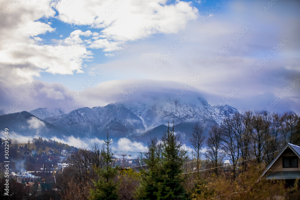 HDR photo of the Tatra Mountains and Great Giewont Peak with the steel Cross between clouds.