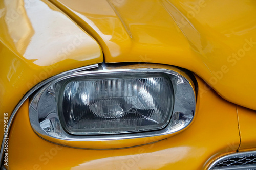 white yellow car headlight. Car headlight in broad daylight. Close-up headlight off. Exterior Detail