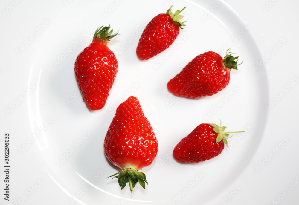 Fresh strawberries isolated on the white plate.