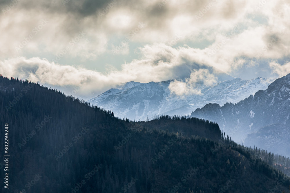 HDR photo of the Tatra Mountains and Great Giewont Peak with the steel Cross between clouds.