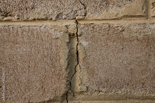 Old brick wall, cracked cinder block