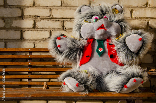 Hedgehog soft toy sits on a bench