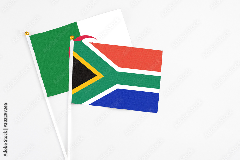 Fototapeta premium South Africa and Algeria stick flags on white background. High quality fabric, miniature national flag. Peaceful global concept.White floor for copy space.