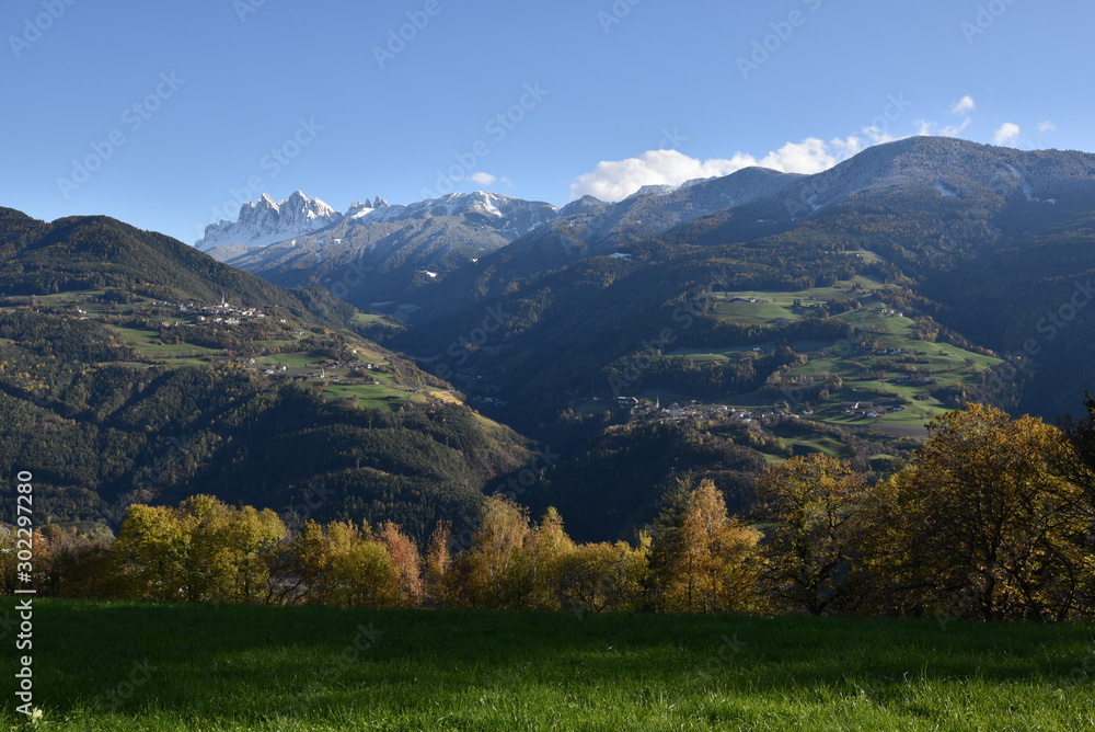 Autumn landscape with villages on hills in Dolomites, Italy