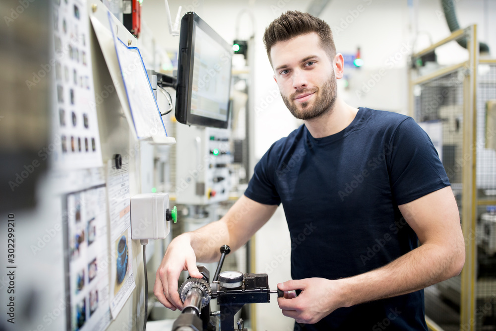 Portrait of a confident man working in a modern factory operating a machine Portrait of a confident man working in a modern factory operating a machine