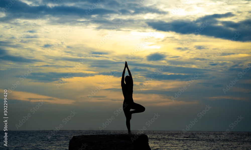 woman is practicing yoga at seashore