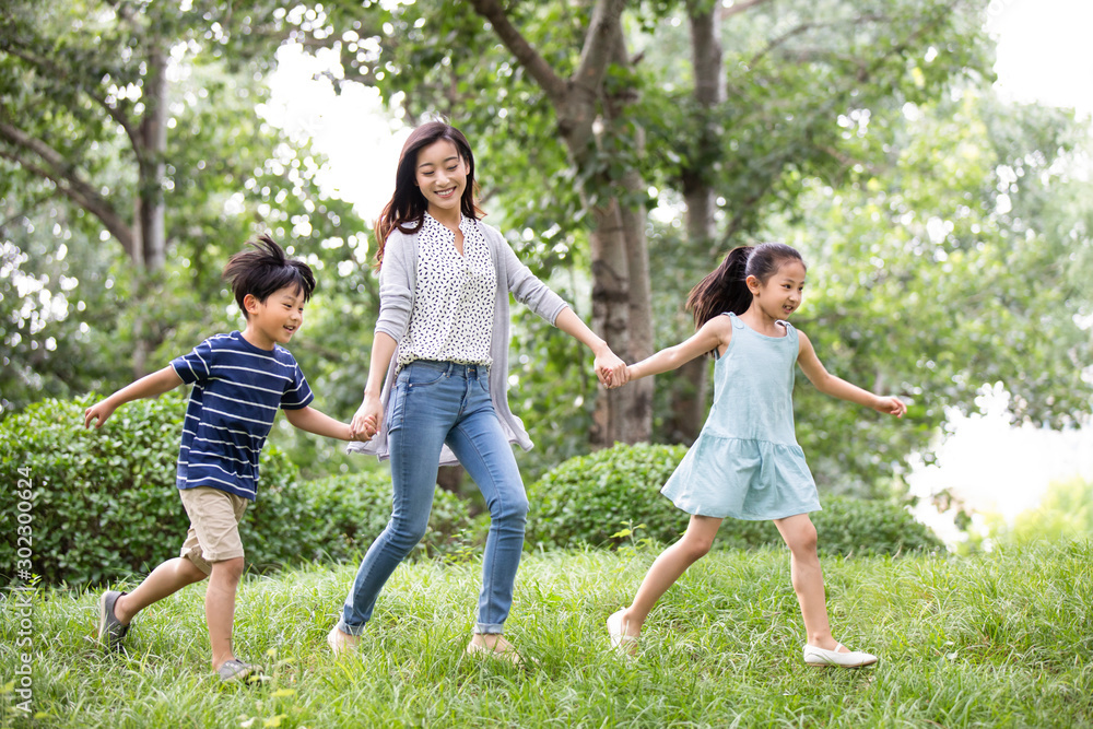 Happy young Chinese family running on grass Happy young Chinese family running on grass
