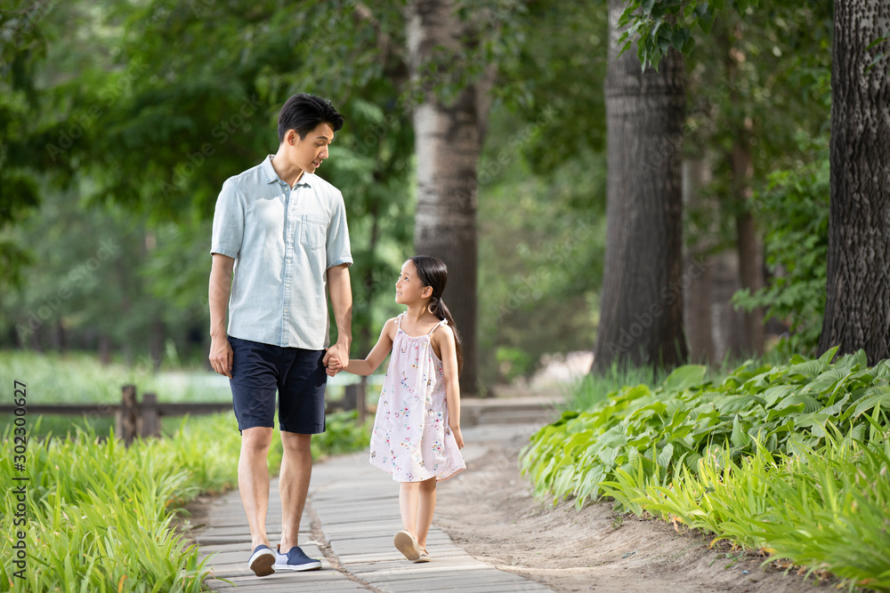 Happy Chinese father and daughter walking in park Happy Chinese father and daughter walking in park