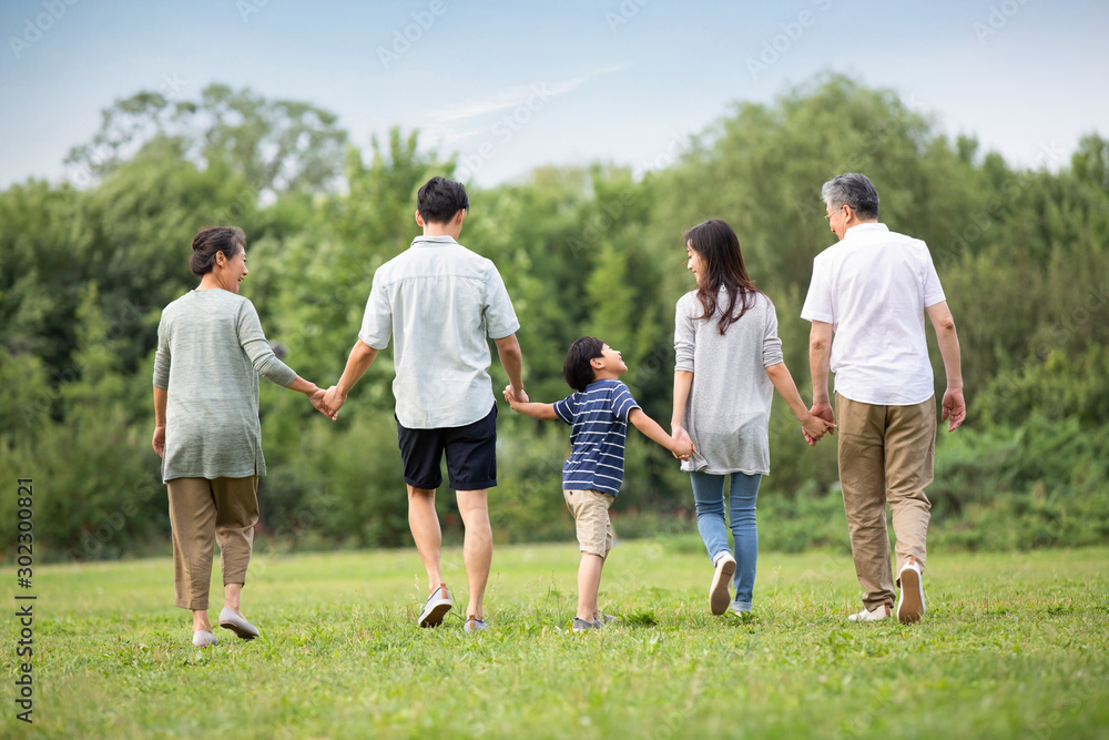 Happy Chinese family walking on grass Happy Chinese family walking on grass