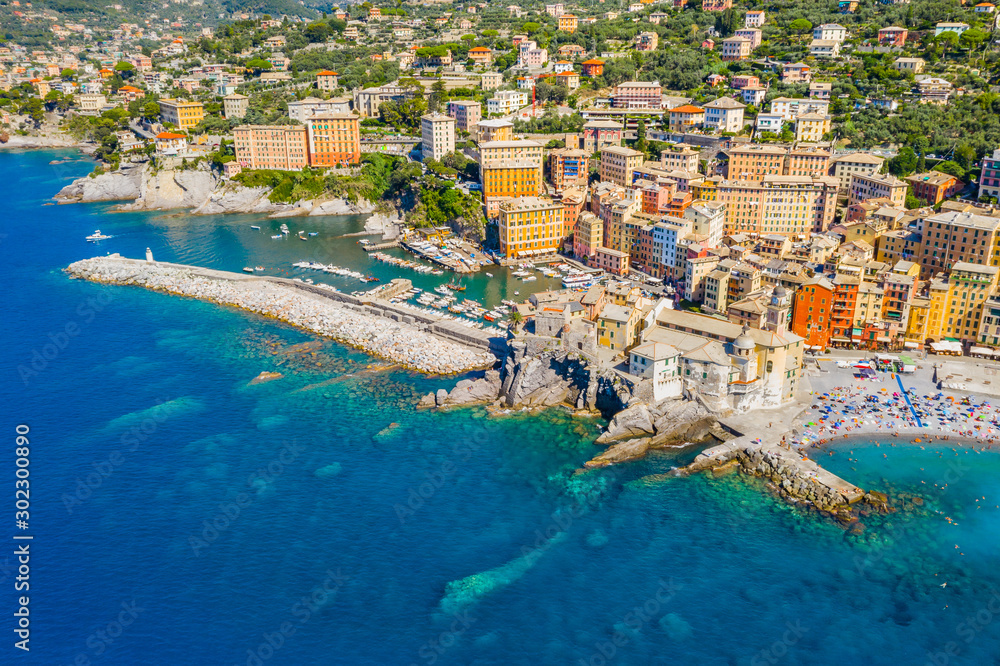 Aerial view of Camogli. Panorama of Castle della Dragonara and Basilica Santa Maria Assunta. Colorful buildings near the ligurian sea beach. View from above on boats and yachts moored in marina with