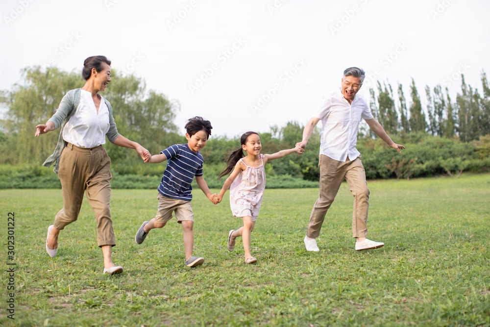 Happy Chinese family running on grass Happy Chinese family running on grass